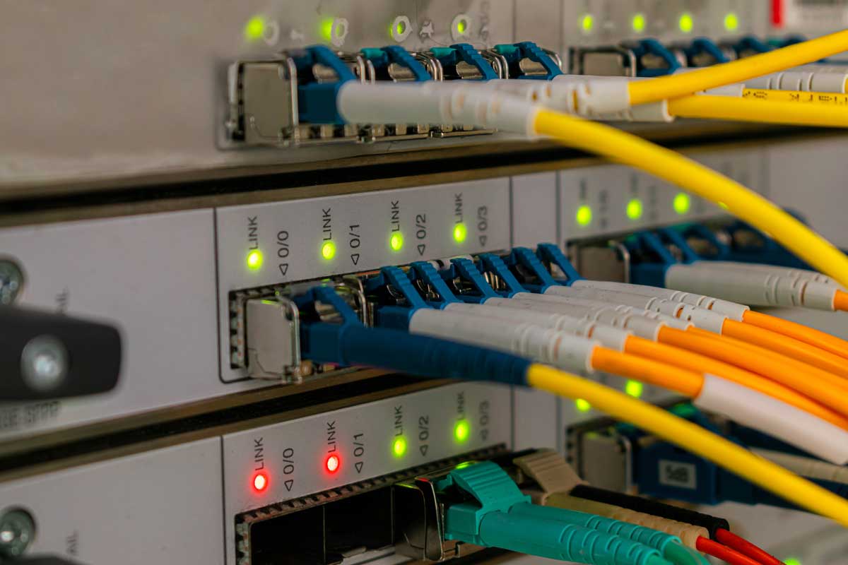 Connessioni in fibra ottica e rame su pannello di rete, cablaggio strutturato per infrastrutture aziendali e data center.