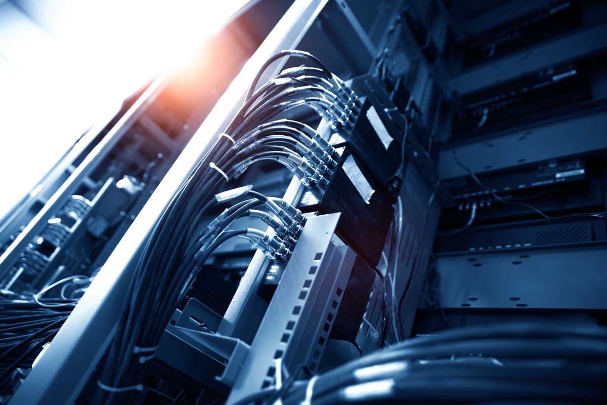 Cavi in fibra ottica collegati a un patch panel, immagine di infrastruttura per trasmissione dati e comunicazioni VoIP.