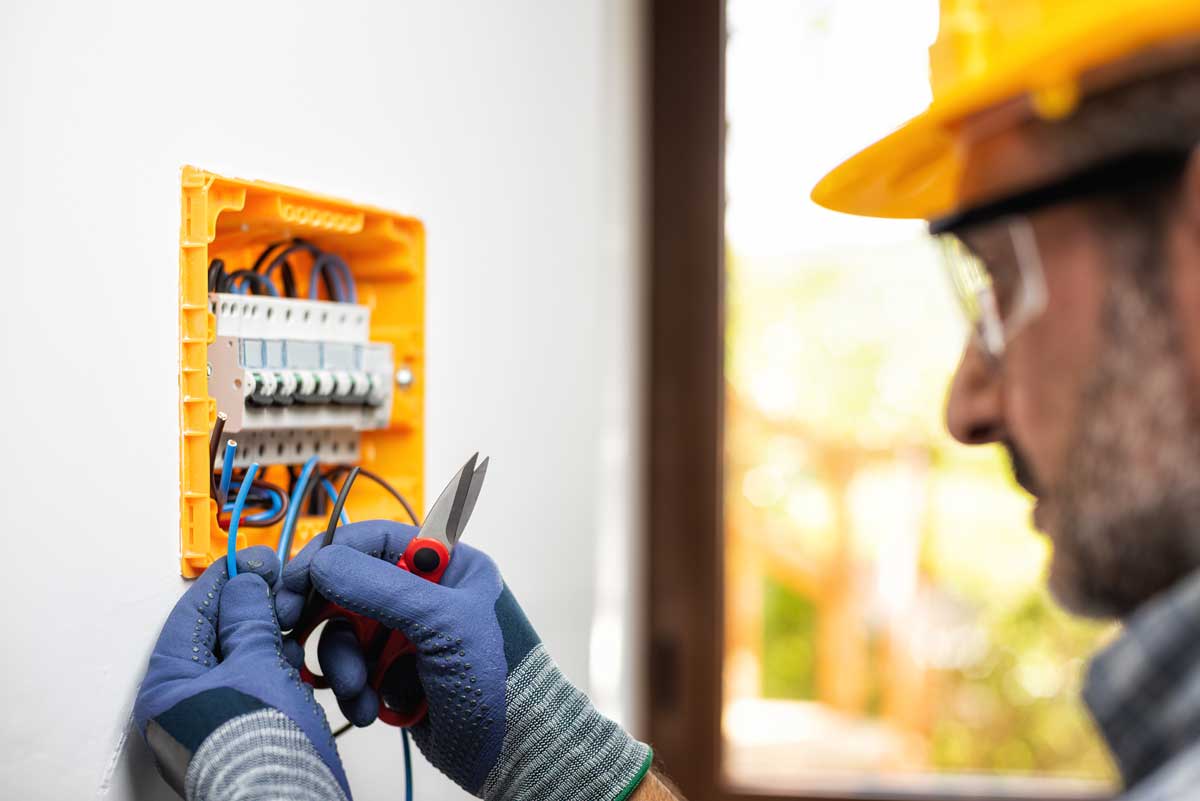 Elettricista al lavoro su quadro elettrico da incasso per impianto civile con strumenti professionali