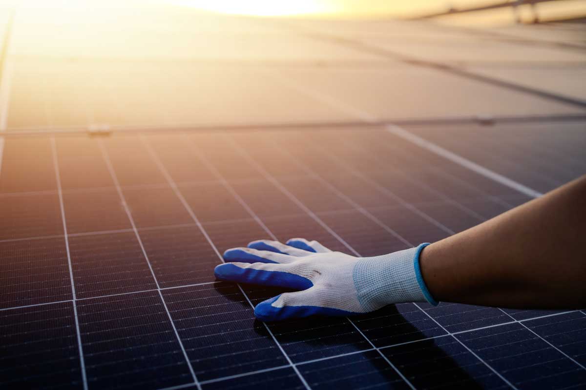 Tecnico specializzato installa pannelli solari su tetto aziendale con attrezzatura professionale